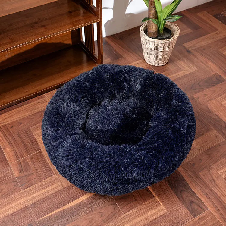 Soft round navy pet bed with plush faux fur design, perfect for providing comfort to pets.