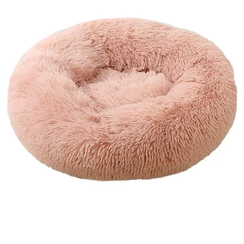 Soft round pet bed in pink faux fur, designed for ultimate comfort and coziness for pets.